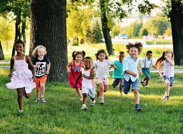 Young children running through a park